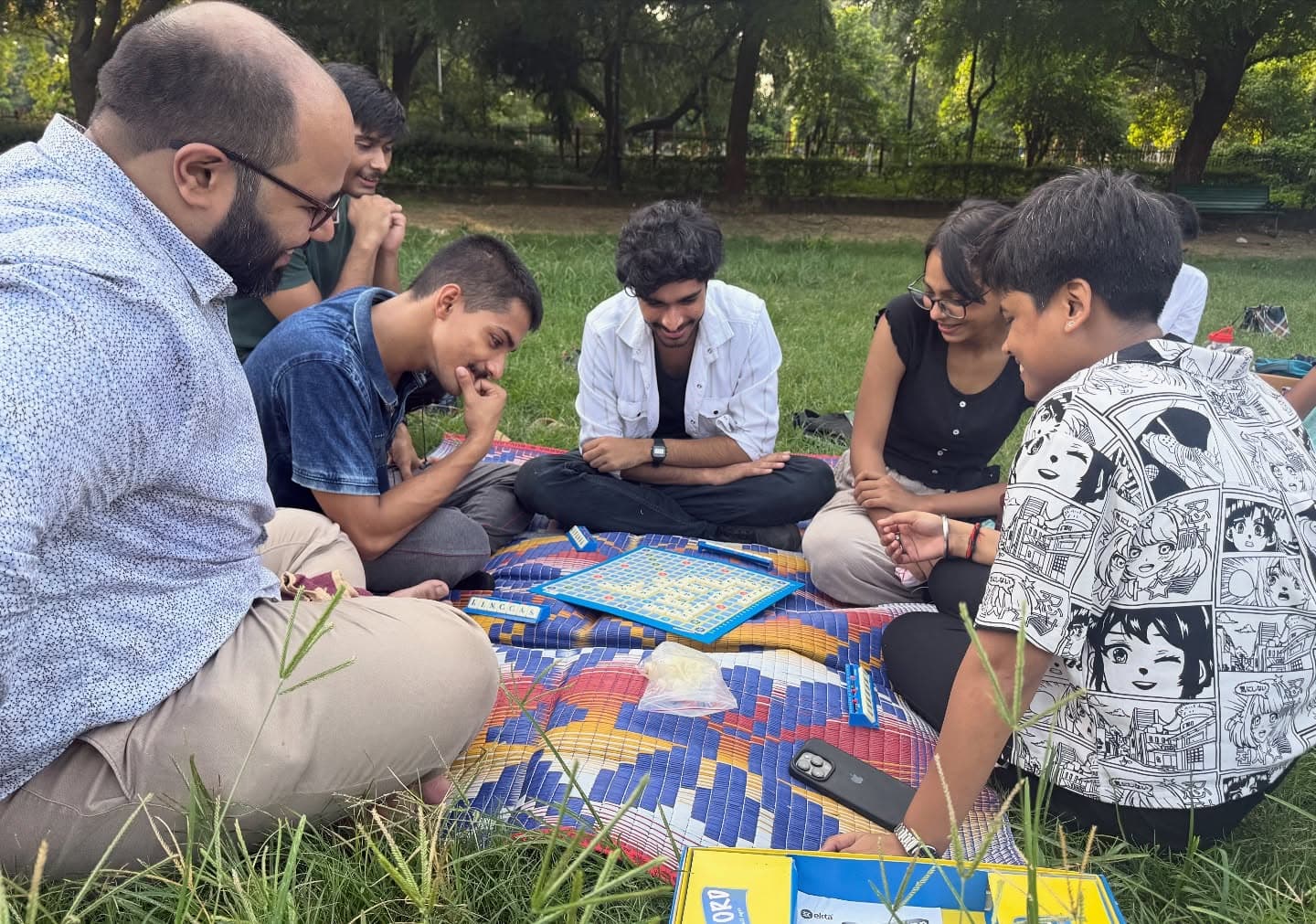 A group gathered outdoors around a board game